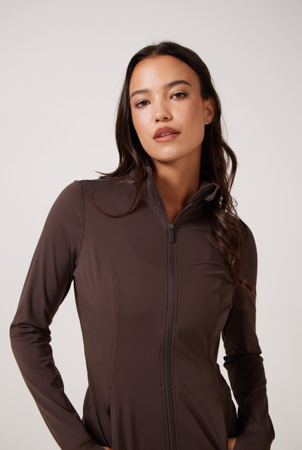 Brown Lightweight performance jacket with a smooth, sculpting fit, full zip front, high collar, and stretch fabric designed for everyday movement and layering.