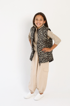 Kids Leopard x Black Gilet™ — sleeveless kids’ puffer vest in bold leopard print with black accents, a fun winter essential in South Africa