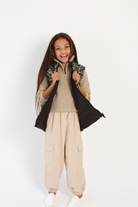 Kids Leopard x Black Gilet™ — sleeveless kids’ puffer vest in bold leopard print with black accents, a fun winter essential in South Africa