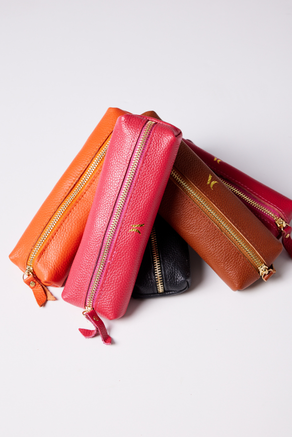 Leather Vanity Bags — assorted colors including orange, pink, red, tan, and black, each with gold zipper detail