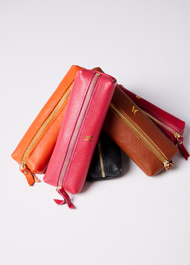 Leather Vanity Bags — assorted colors including orange, pink, red, tan, and black, each with gold zipper detail