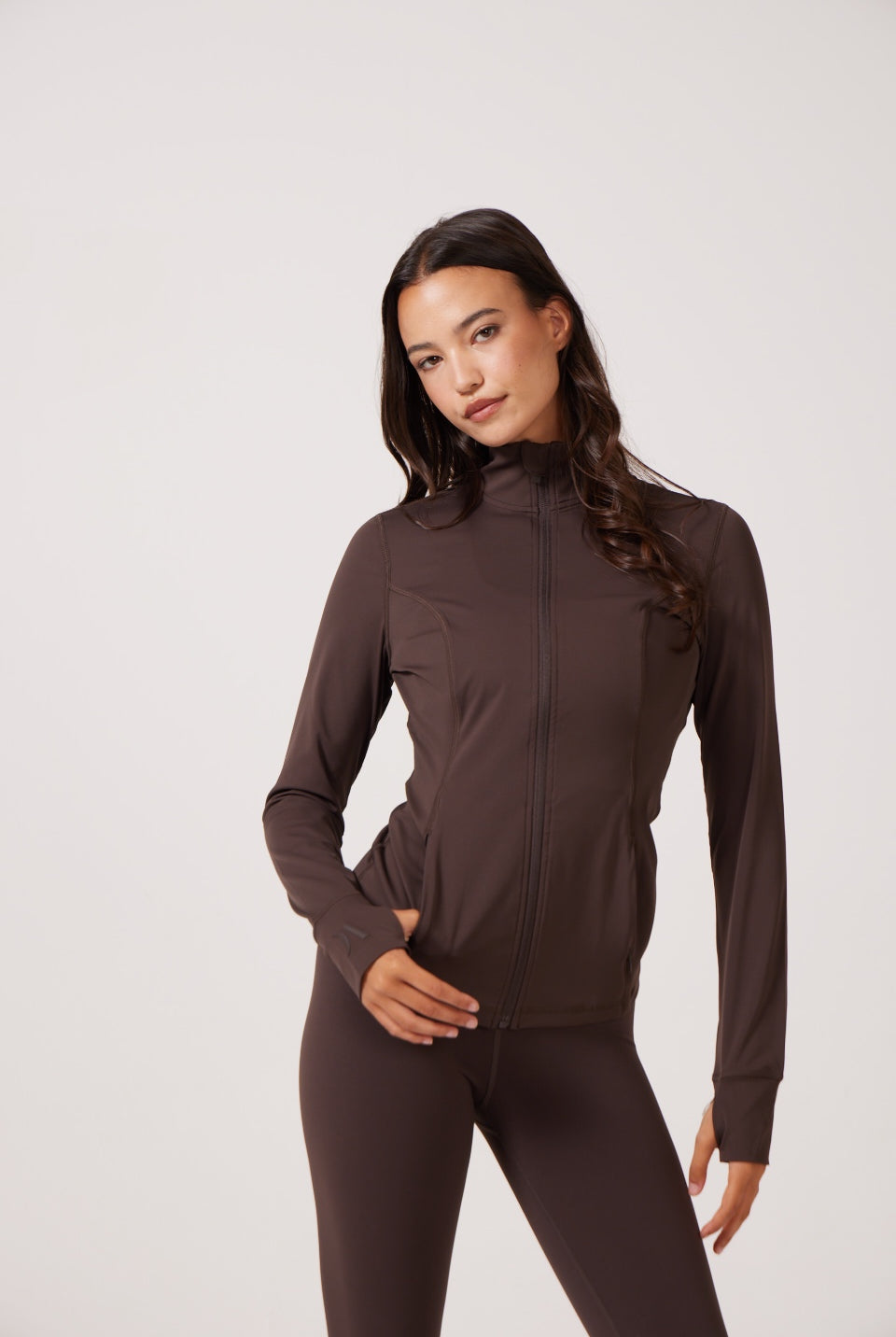 Brown Lightweight performance jacket with a smooth, sculpting fit, full zip front, high collar, and stretch fabric designed for everyday movement and layering.