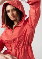 The Coral Spritz raincoat in coral red, lightweight hooded waterproof raincoat ideal for South Africa’s rainy season and wet climate