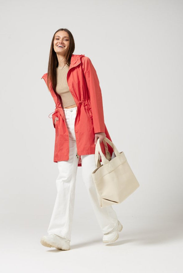 The Coral Spritz raincoat in coral red, lightweight hooded waterproof raincoat ideal for South Africa’s rainy season and wet climate