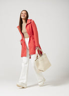 The Coral Spritz raincoat in coral red, lightweight hooded waterproof raincoat ideal for South Africa’s rainy season and wet climate