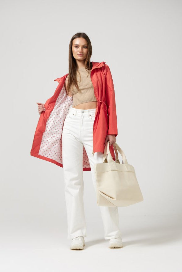 The Coral Spritz raincoat in coral red, lightweight hooded waterproof raincoat ideal for South Africa’s rainy season and wet climate