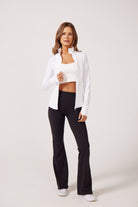 White Lightweight performance jacket with a smooth, sculpting fit, full zip front, high collar, and stretch fabric designed for everyday movement and layering.