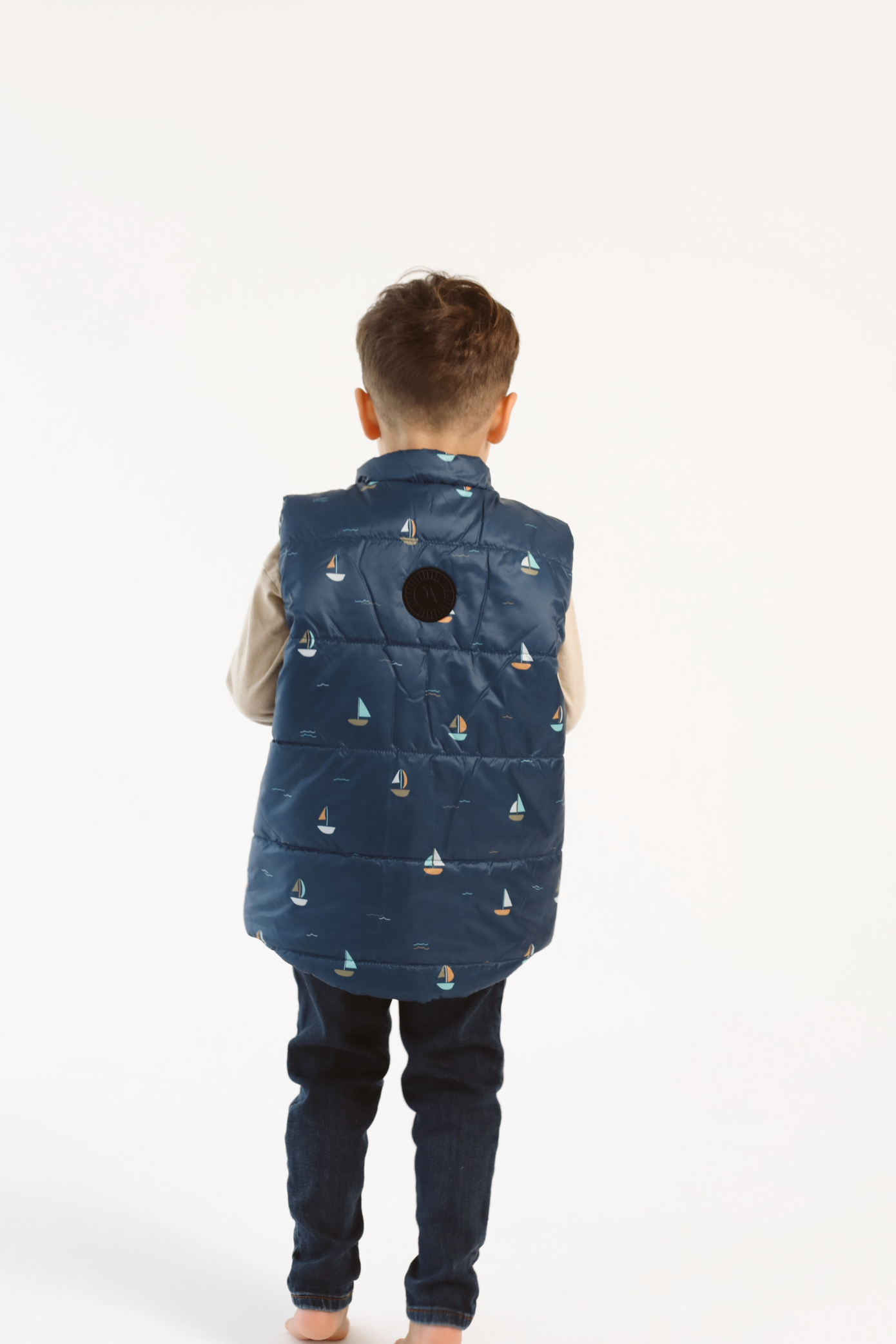 Kids Boats x Navy Gilet™ — sleeveless navy puffer vest with playful boat print, a versatile layer for kids in South Africa