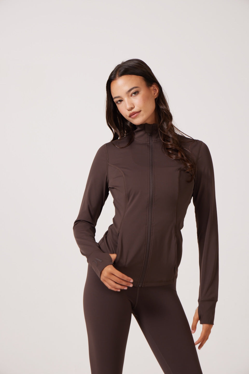 Brown Lightweight performance jacket with a smooth, sculpting fit, full zip front, high collar, and stretch fabric designed for everyday movement and layering.