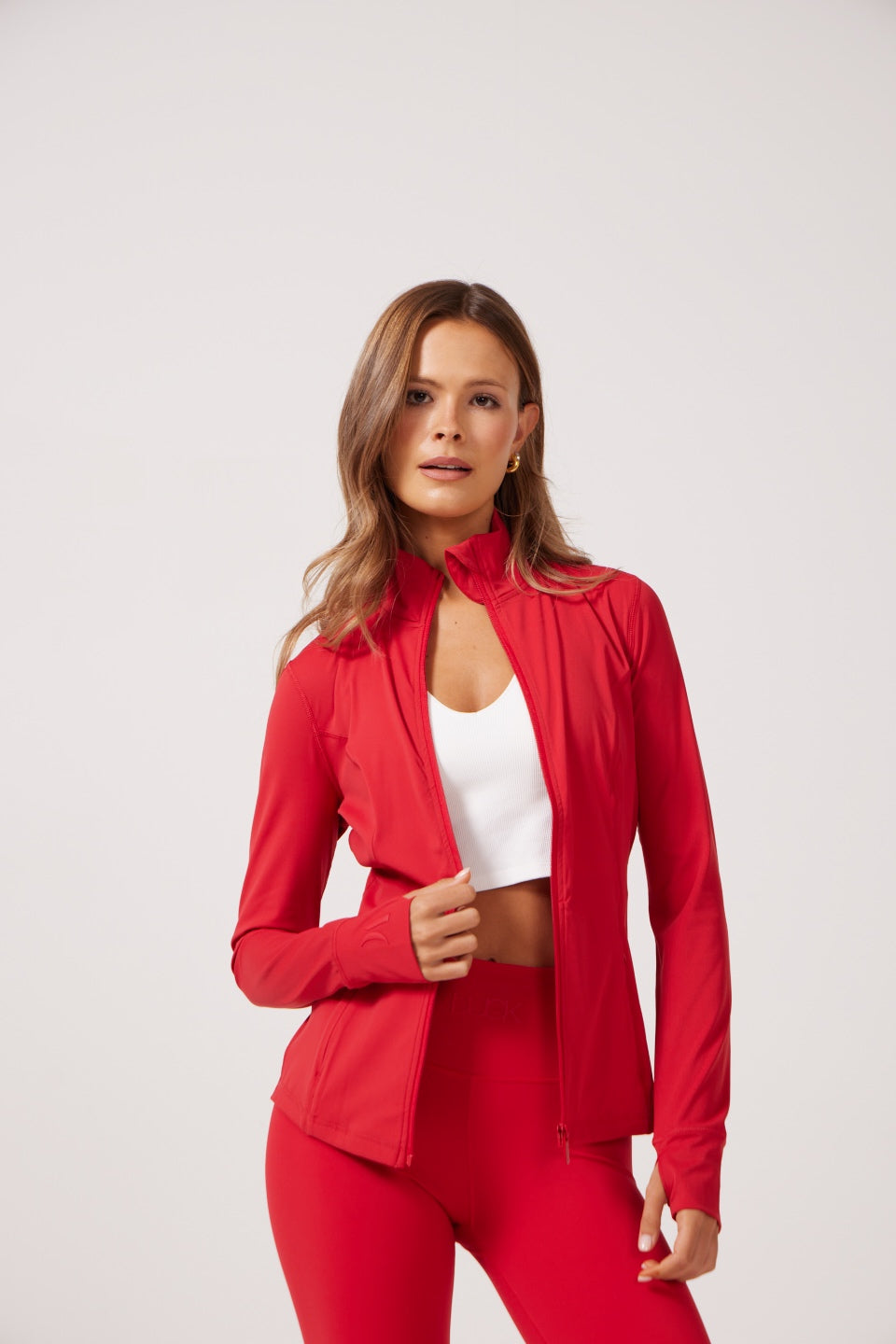 Red Lightweight performance jacket with a smooth, sculpting fit, full zip front, high collar, and stretch fabric designed for everyday movement and layering.