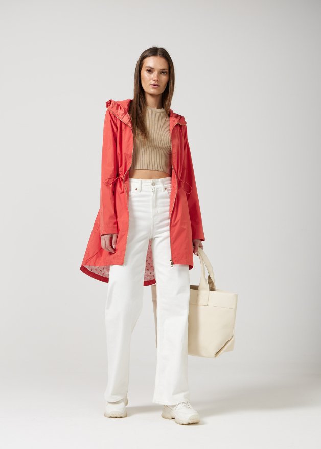 The Coral Spritz raincoat in coral red, lightweight hooded waterproof raincoat ideal for South Africa’s rainy season and wet climate
